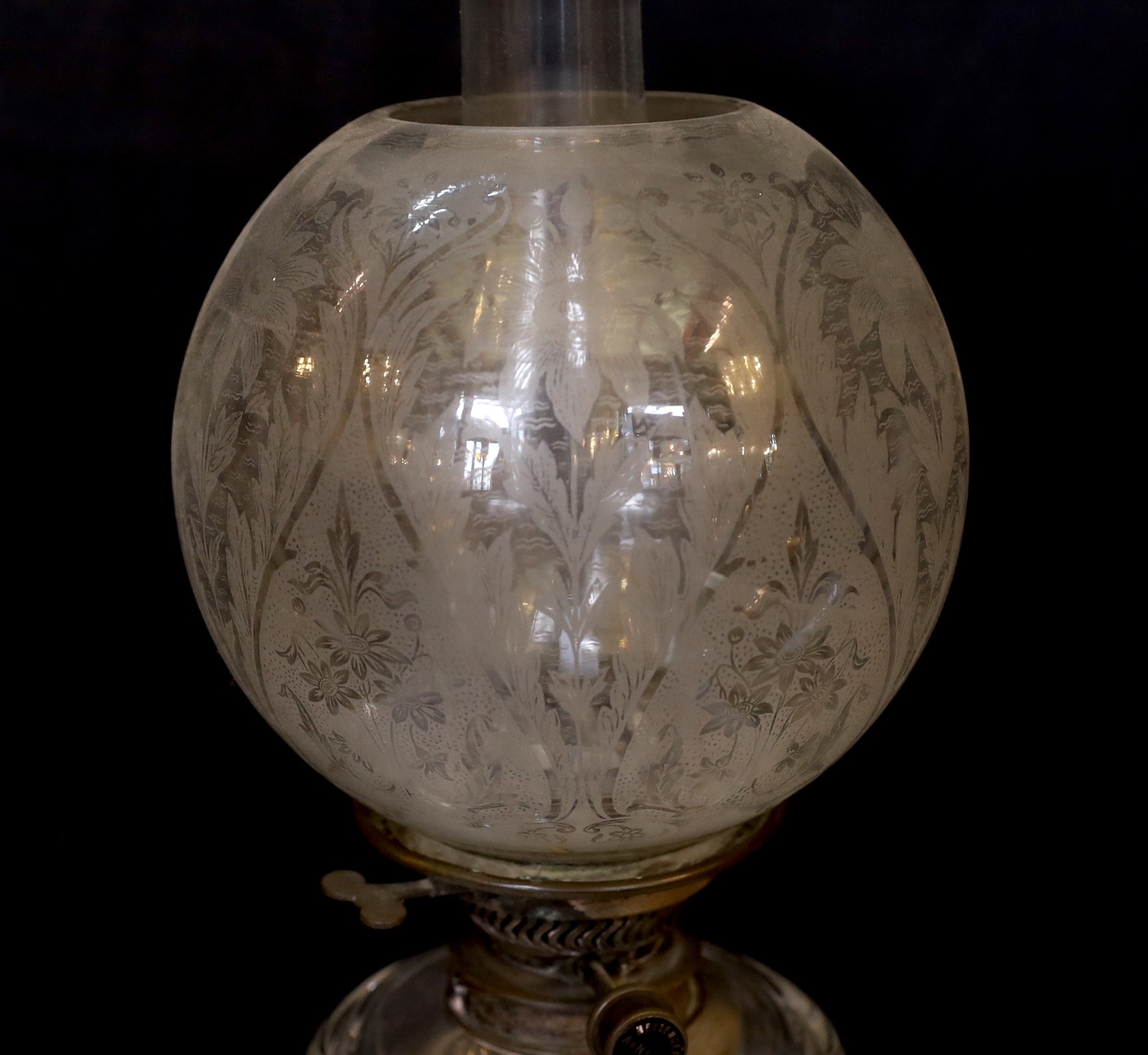 An Edwardian brass column oil lamp with cut glass reservoir, ANCS mechanism and etched shade, height overall 70cm